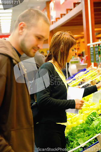 Image of happy couple buying fruits in hypermarket