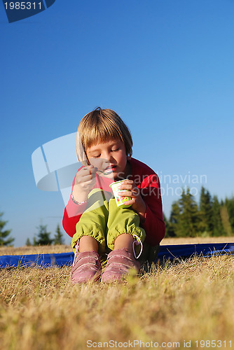 Image of happy girl eating healthy food in nature
