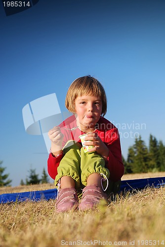 Image of happy girl eating healthy food in nature