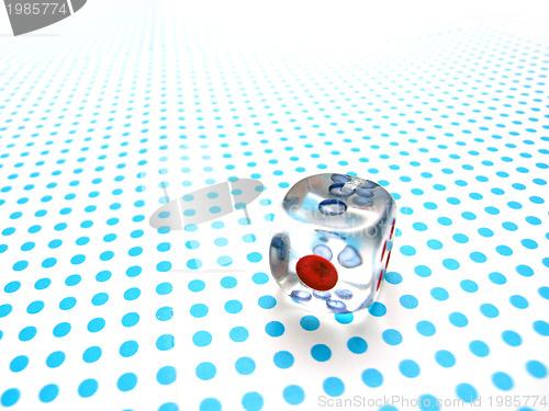 Image of gamblig dice on blue dotted background