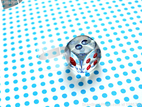 Image of gamblig dice on blue dotted background