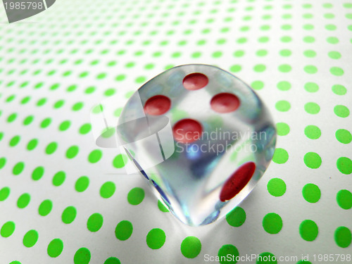 Image of gambling dice on green dotted background