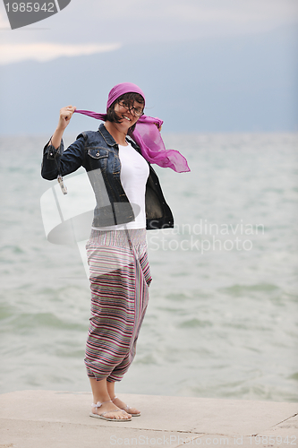 Image of beautiful young woman on beach with scarf
