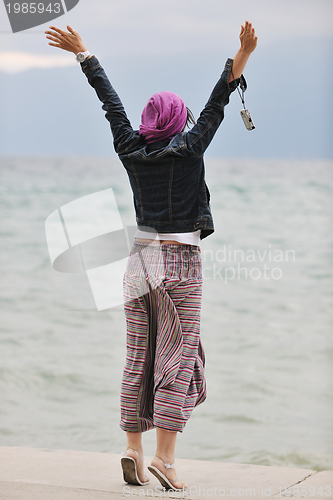 Image of beautiful young woman on beach with scarf