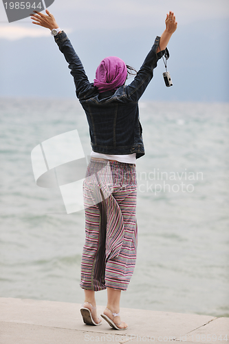 Image of beautiful young woman on beach with scarf