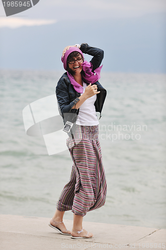 Image of beautiful young woman on beach with scarf