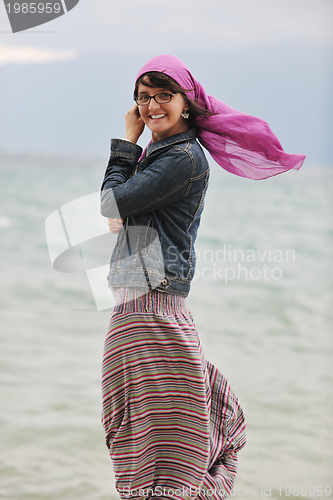 Image of beautiful young woman on beach with scarf