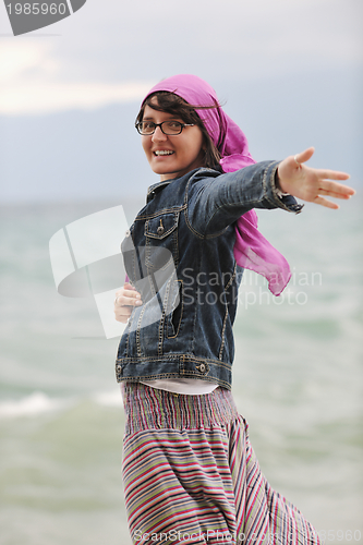 Image of beautiful young woman on beach with scarf