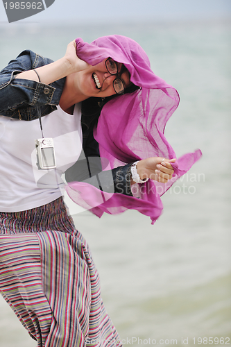 Image of beautiful young woman on beach with scarf