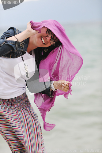 Image of beautiful young woman on beach with scarf