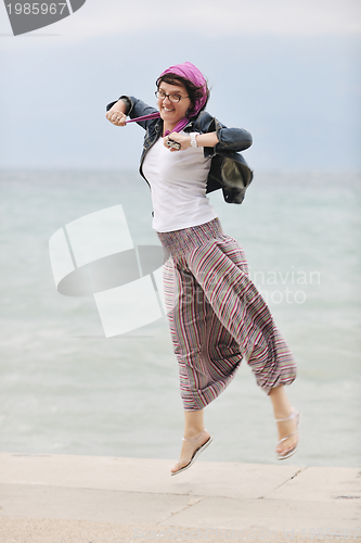 Image of beautiful young woman on beach with scarf