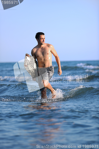 Image of Portrait of a young  kitsurf  man at beach on sunset