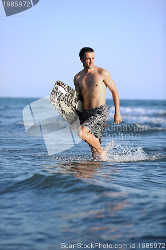 Image of Portrait of a young  kitsurf  man at beach on sunset
