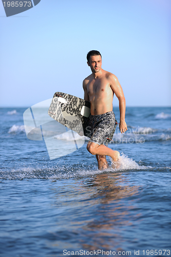 Image of Portrait of a young  kitsurf  man at beach on sunset
