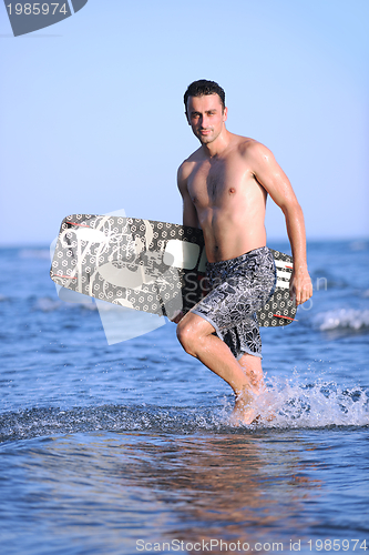 Image of Portrait of a young  kitsurf  man at beach on sunset