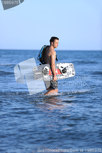 Image of Portrait of a young  kitsurf  man at beach on sunset