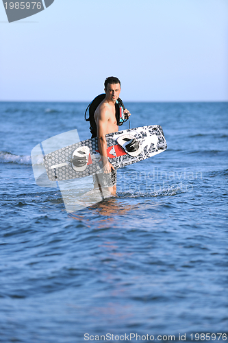 Image of Portrait of a young  kitsurf  man at beach on sunset