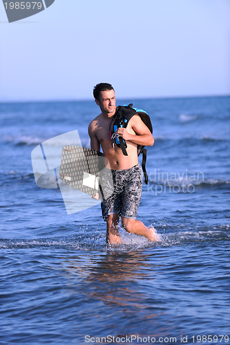 Image of Portrait of a young  kitsurf  man at beach on sunset