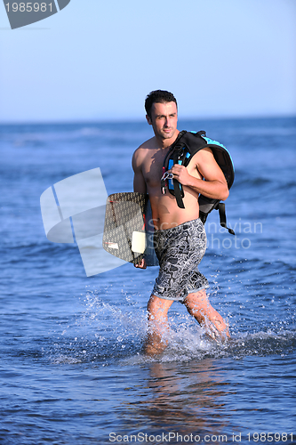 Image of Portrait of a young  kitsurf  man at beach on sunset