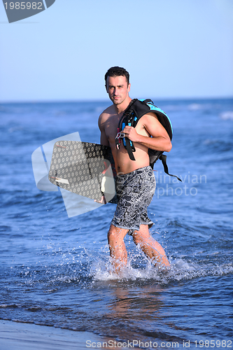 Image of Portrait of a young  kitsurf  man at beach on sunset