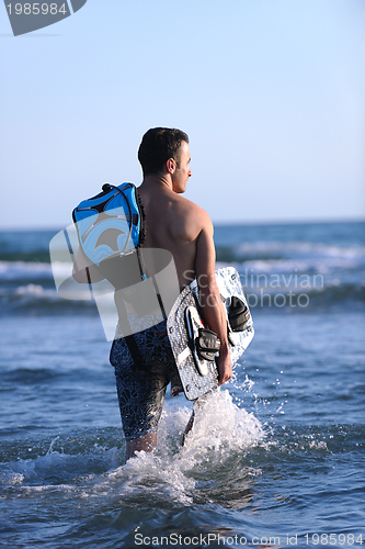 Image of Portrait of a young  kitsurf  man at beach on sunset