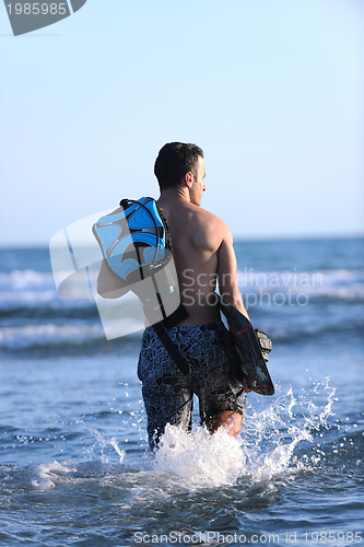 Image of Portrait of a young  kitsurf  man at beach on sunset