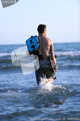 Image of Portrait of a young  kitsurf  man at beach on sunset