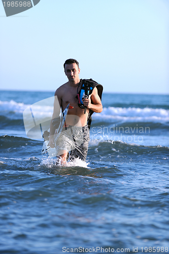 Image of Portrait of a young  kitsurf  man at beach on sunset