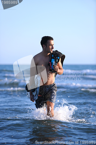 Image of Portrait of a young  kitsurf  man at beach on sunset