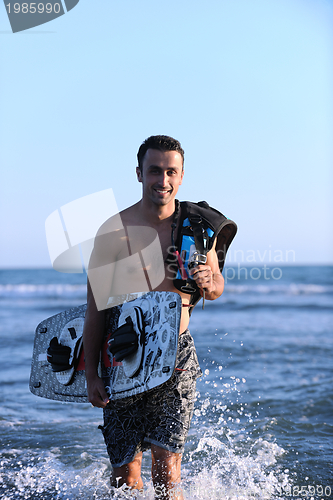 Image of Portrait of a young  kitsurf  man at beach on sunset