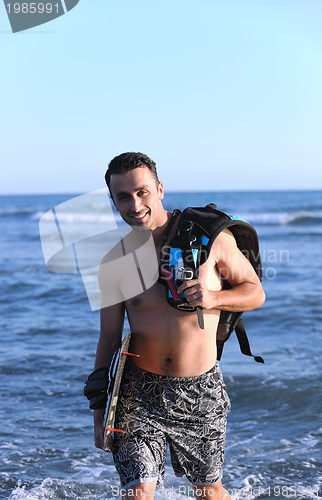 Image of Portrait of a young  kitsurf  man at beach on sunset