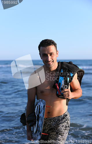 Image of Portrait of a young  kitsurf  man at beach on sunset