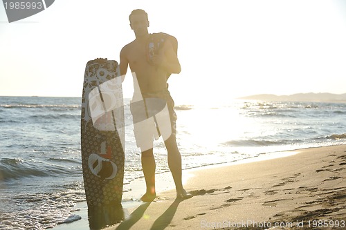 Image of Portrait of a young  kitsurf  man at beach on sunset