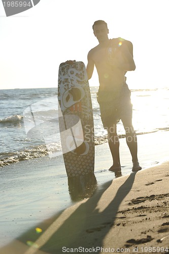 Image of Portrait of a young  kitsurf  man at beach on sunset