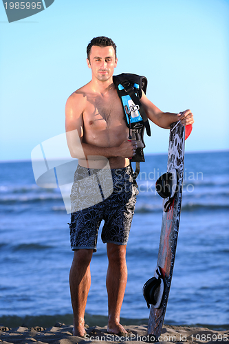 Image of Portrait of a young  kitsurf  man at beach on sunset