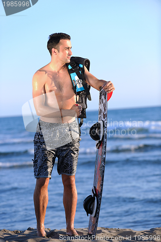 Image of Portrait of a young  kitsurf  man at beach on sunset