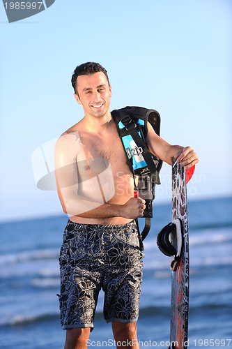 Image of Portrait of a young  kitsurf  man at beach on sunset