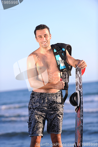 Image of Portrait of a young  kitsurf  man at beach on sunset