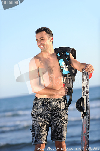 Image of Portrait of a young  kitsurf  man at beach on sunset