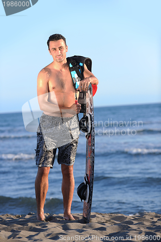 Image of Portrait of a young  kitsurf  man at beach on sunset