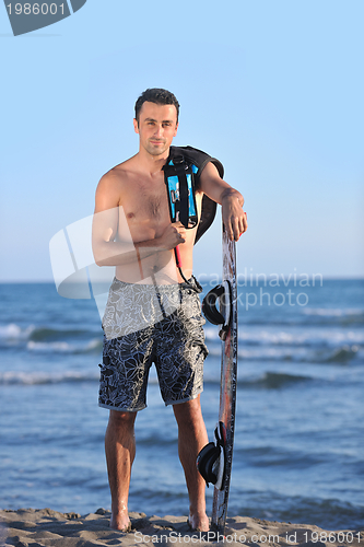 Image of Portrait of a young  kitsurf  man at beach on sunset