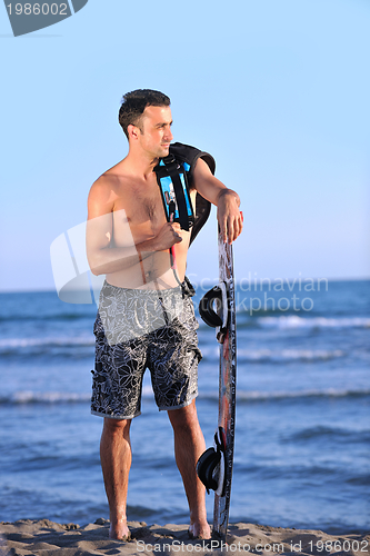 Image of Portrait of a young  kitsurf  man at beach on sunset