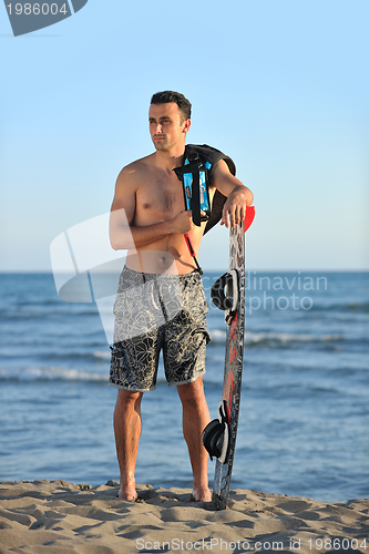Image of Portrait of a young  kitsurf  man at beach on sunset