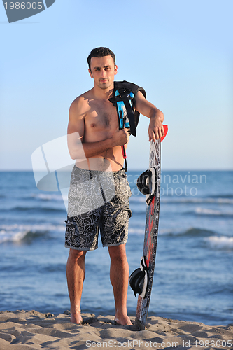 Image of Portrait of a young  kitsurf  man at beach on sunset
