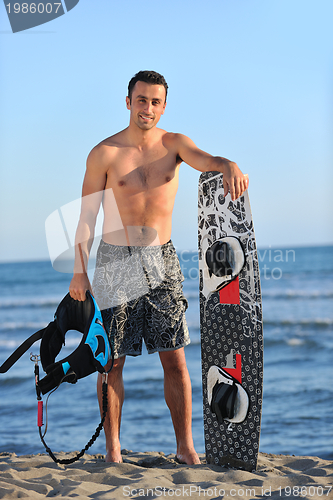 Image of Portrait of a young  kitsurf  man at beach on sunset