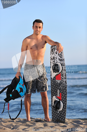 Image of Portrait of a young  kitsurf  man at beach on sunset