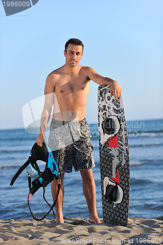 Image of Portrait of a young  kitsurf  man at beach on sunset