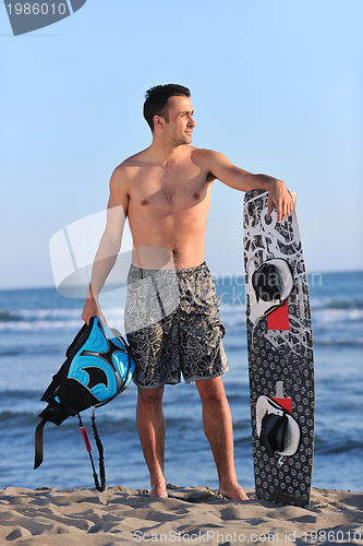 Image of Portrait of a young  kitsurf  man at beach on sunset