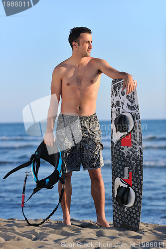 Image of Portrait of a young  kitsurf  man at beach on sunset