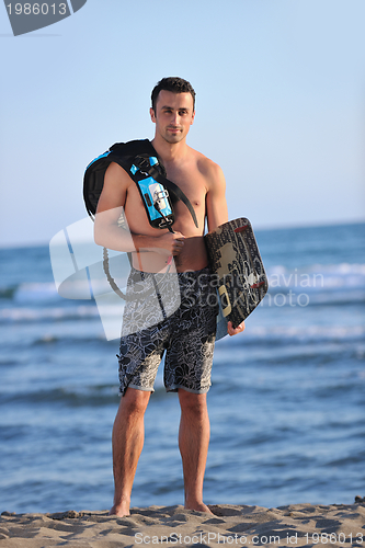 Image of Portrait of a young  kitsurf  man at beach on sunset